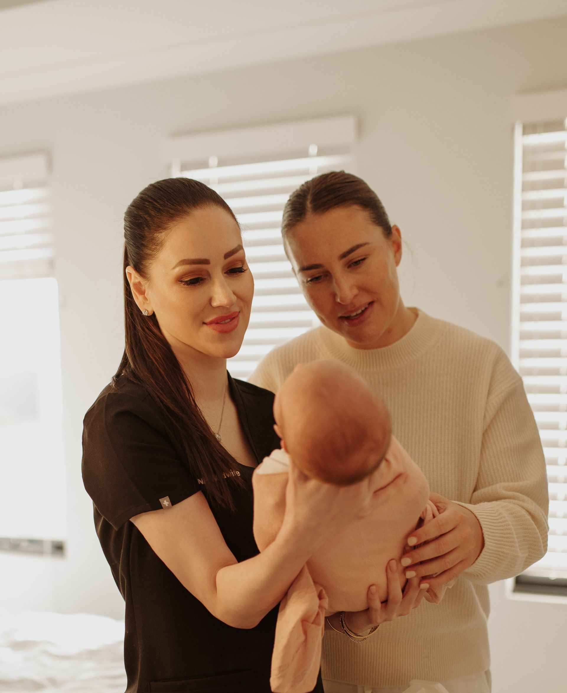 Megan Everett, Nurse Practitioner at Hush Healthcare, providing gentle postnatal and early parenting care while holding an infant in Perth.