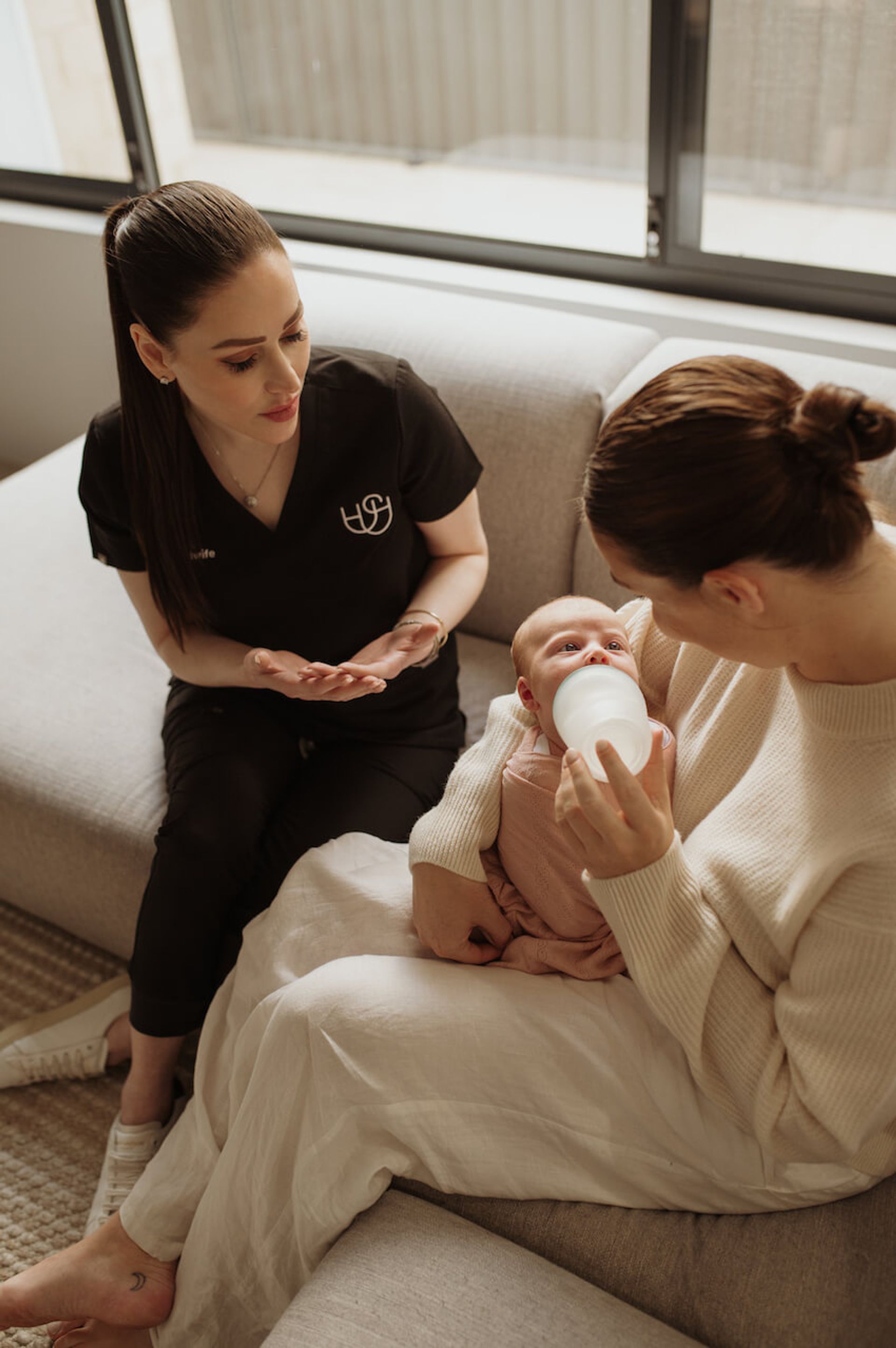 Megan Everett providing feeding support to a new mother bottle-feeding her baby in Perth