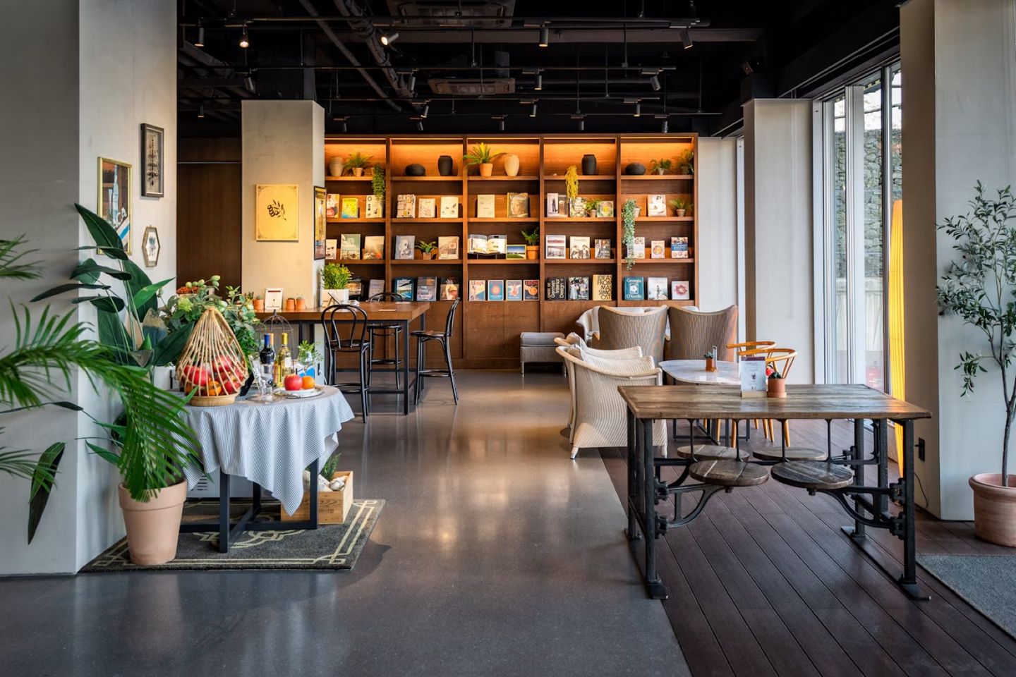 A warm café interior with wooden shelves, plants and tables