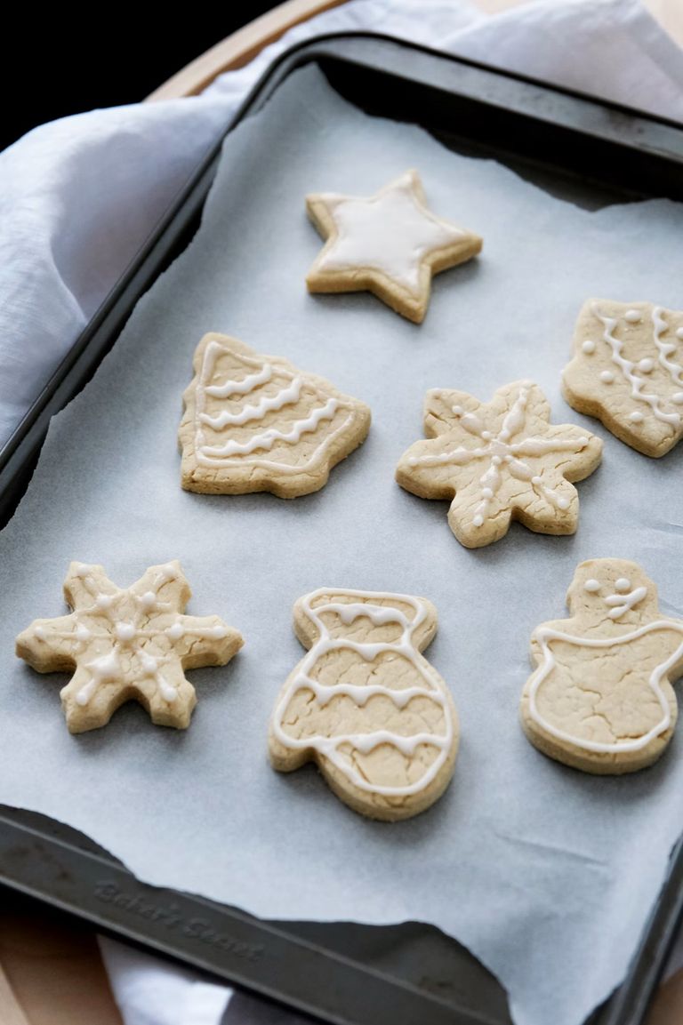 Iced biscuits in star, snowflake and snowman shapes on a baking tray