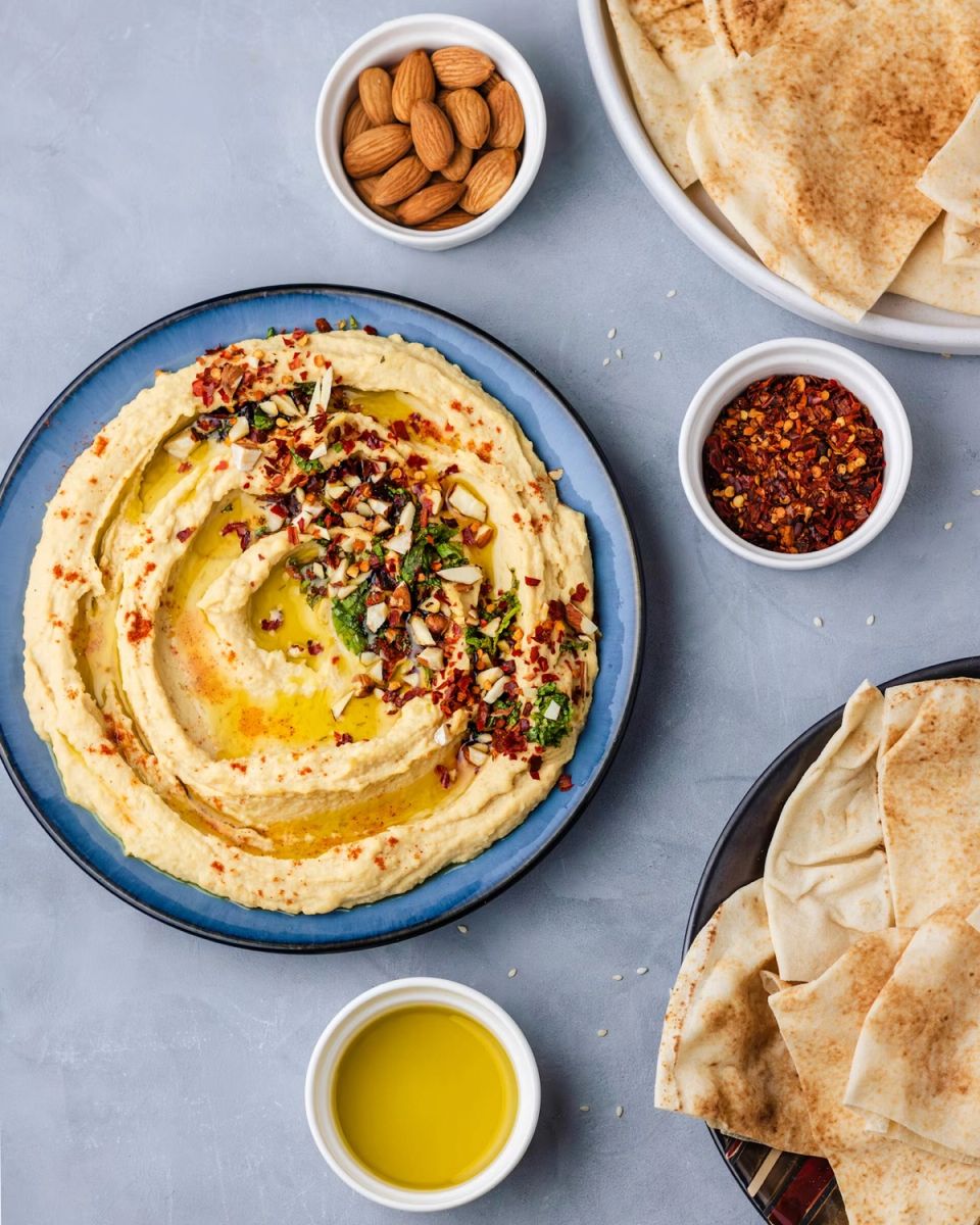Hummus with olive oil, flatbread and small bowls of spices