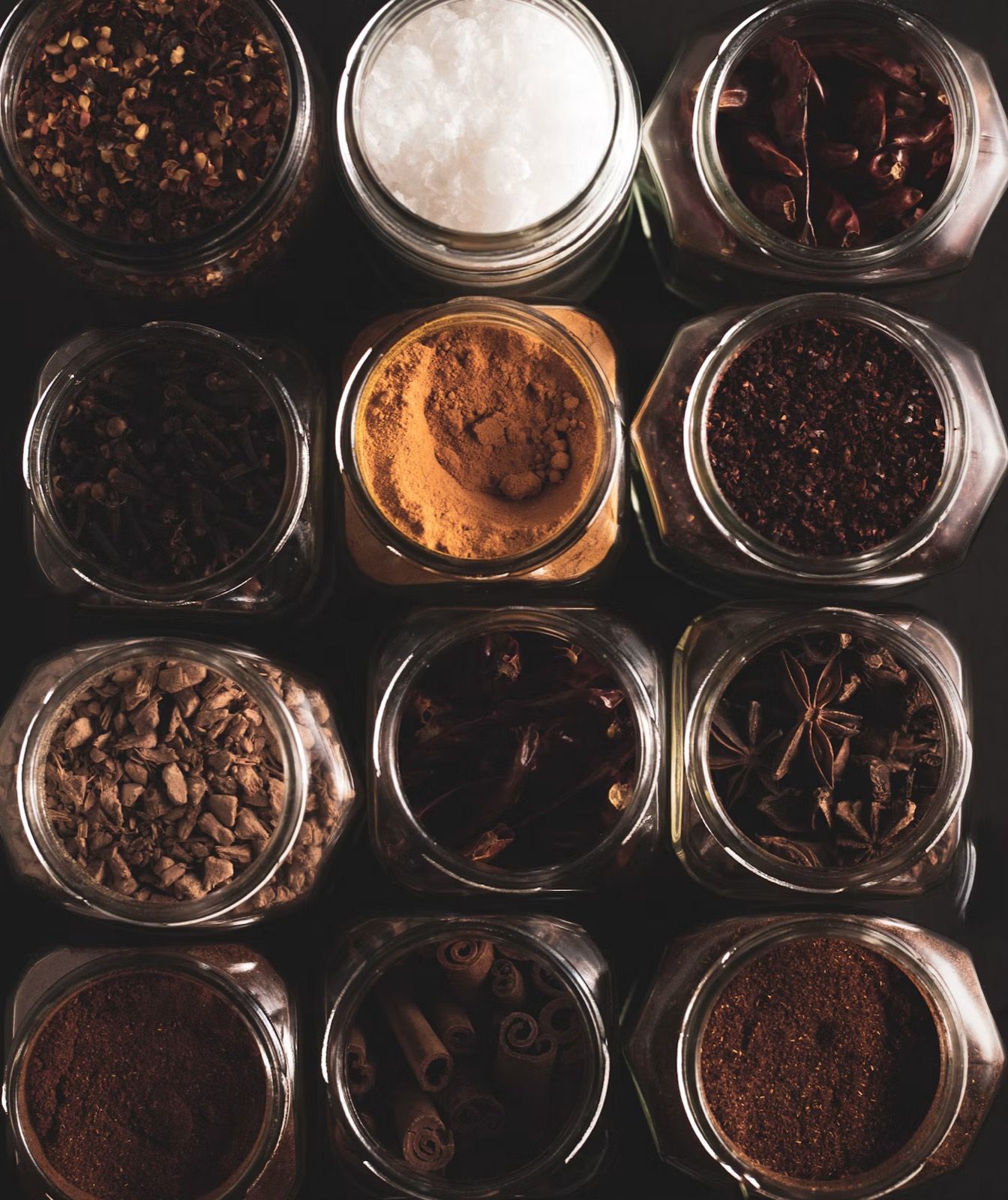 Jars of coffee beans, spices and sugar seen from above