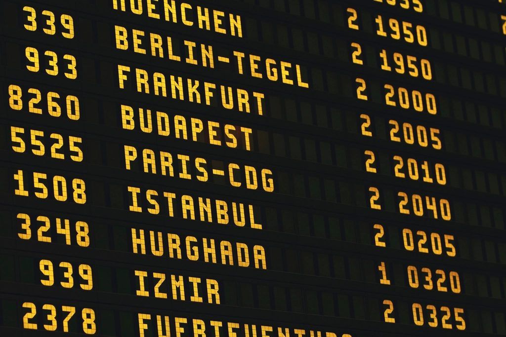 An airport departures board listing European destinations