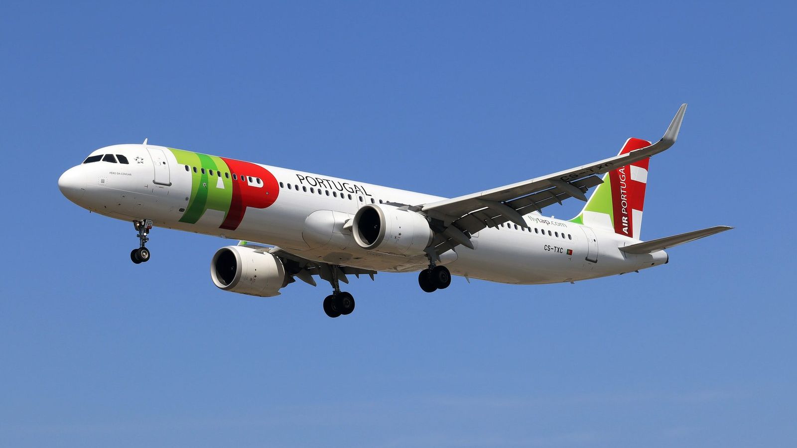 A TAP Air Portugal plane in flight against a blue sky