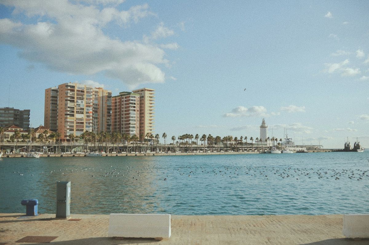 Málaga's palm-lined port and historic lighthouse on the Costa del Sol