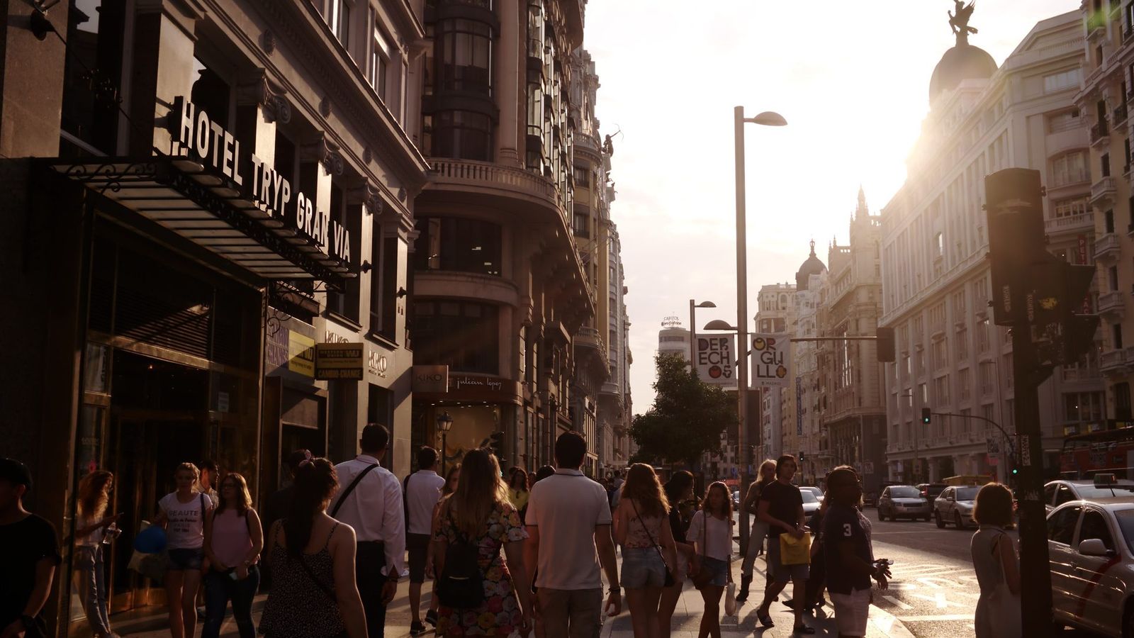 People walking along Gran Vía in Madrid on a sunny evening