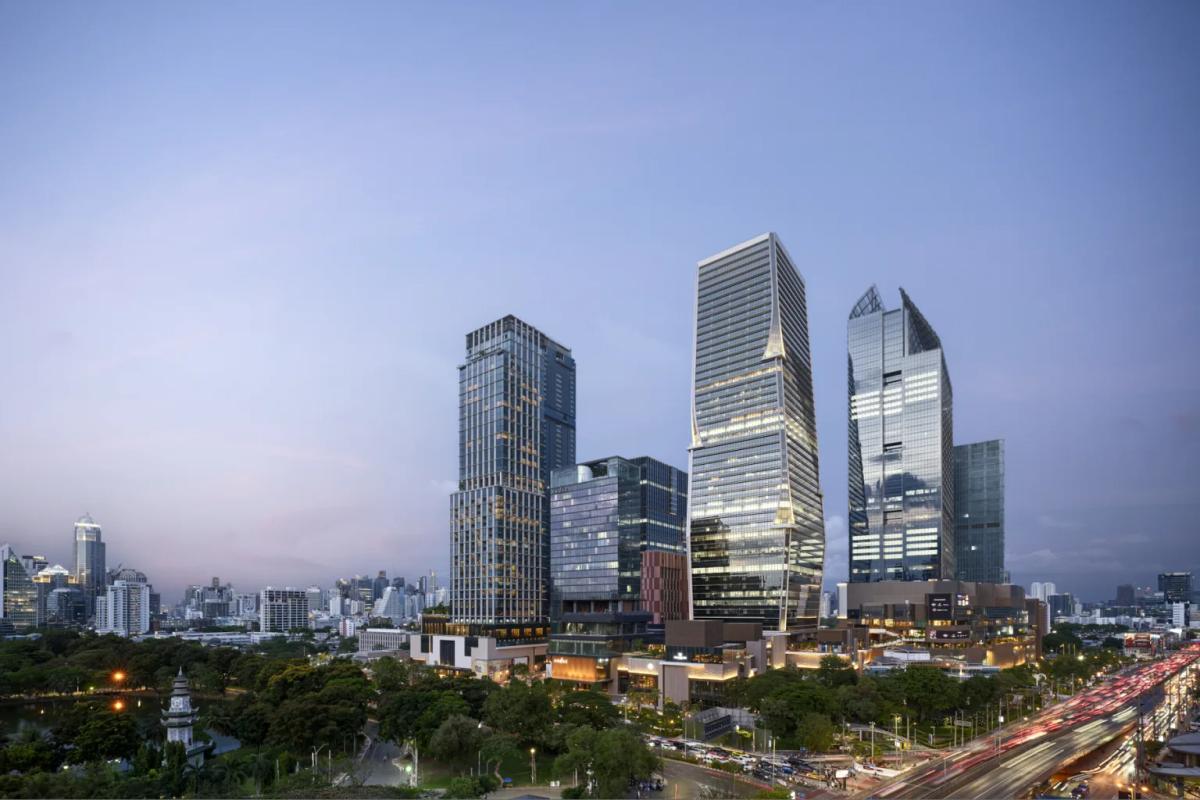 One Bangkok towers and district buildings at dusk, seen from across Lumphini Park.