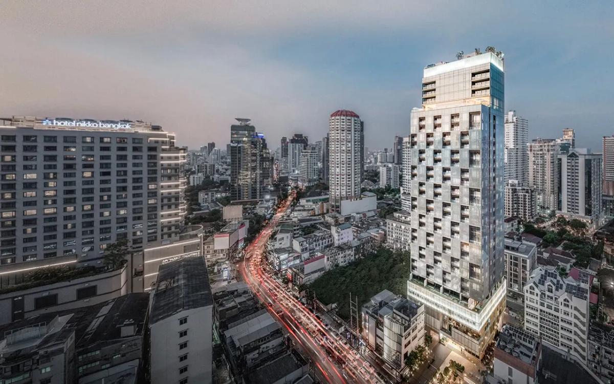 The Strand Thonglor tower and surrounding neighbourhood at dusk, seen from above.
