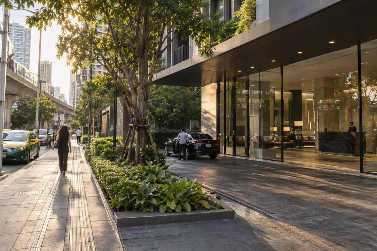 Bangkok condominium entrance with a shaded pedestrian approach and nearby street.