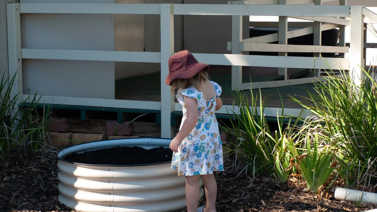 Picture of a child near a small garden bed