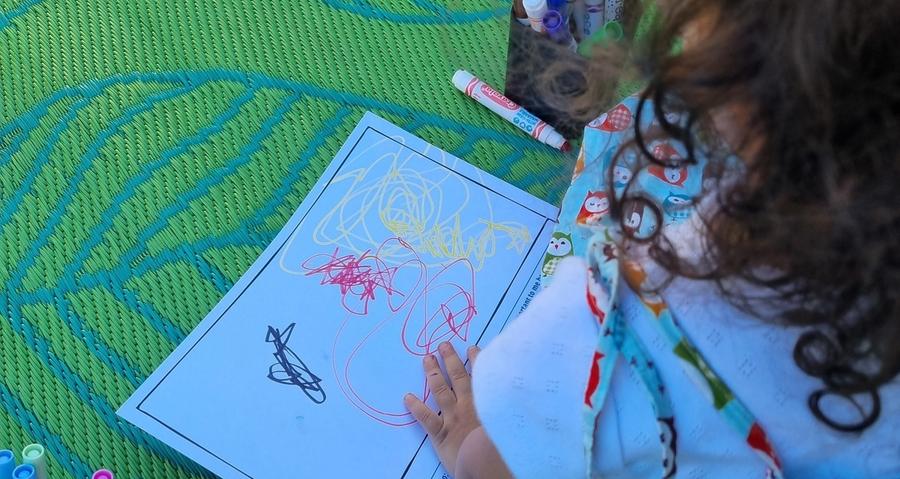 Photo of child on mat colouring