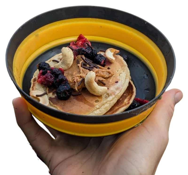 Pancakes mit Beeren, Cashews und Erdnussbutter im Faltnapf