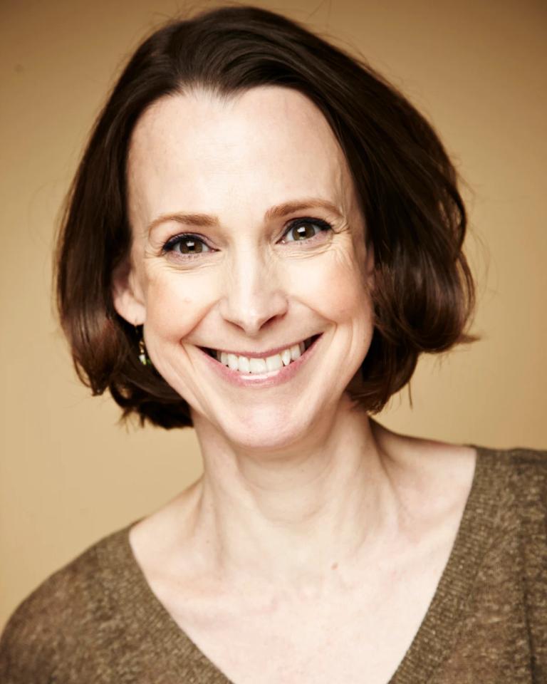 Kate Cagney looks toward the camera, smiling