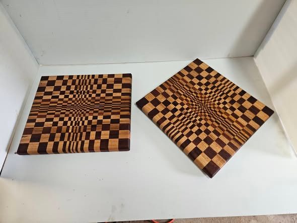 Two geometric chopping boards with alternating light and dark squares forming an optical pattern