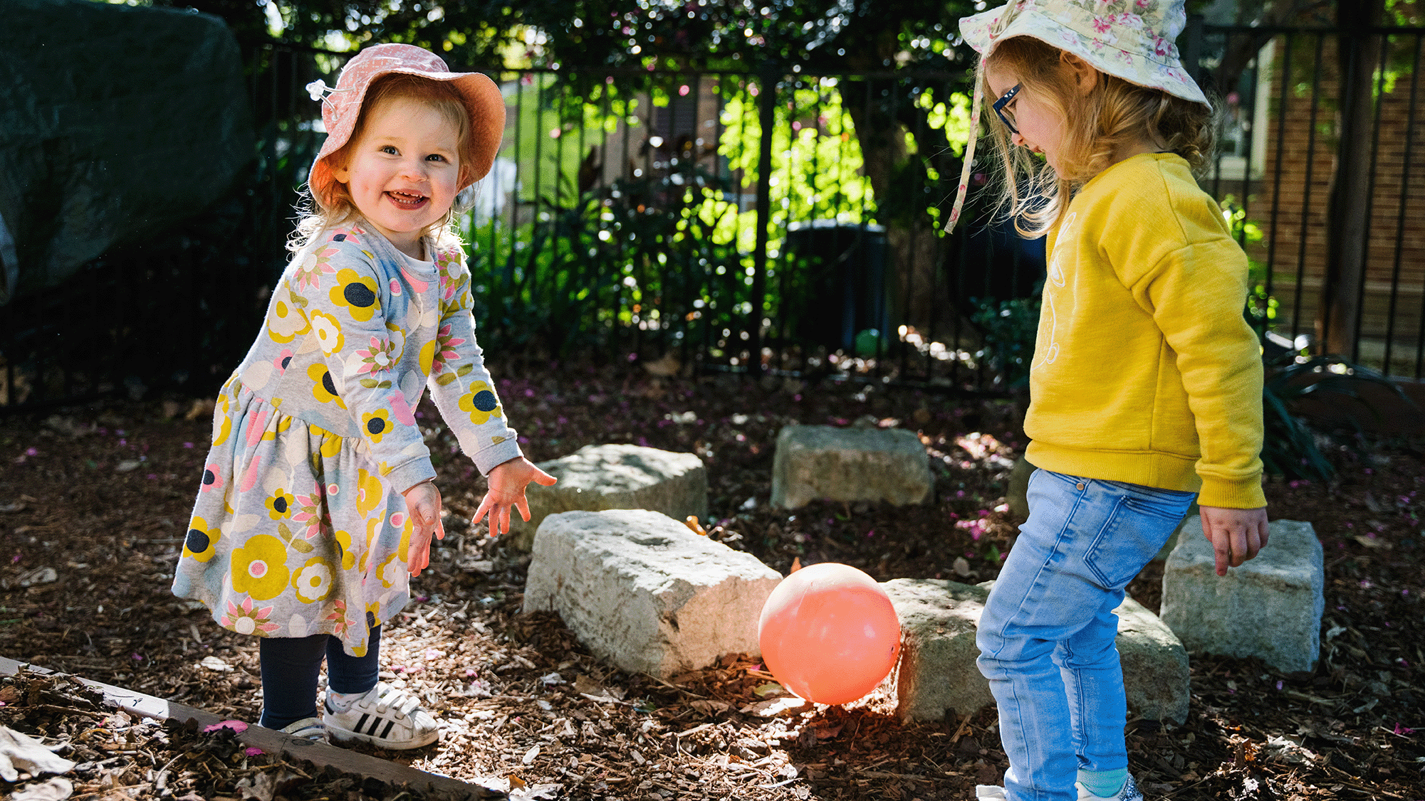 Two children playing outdoors with balloon