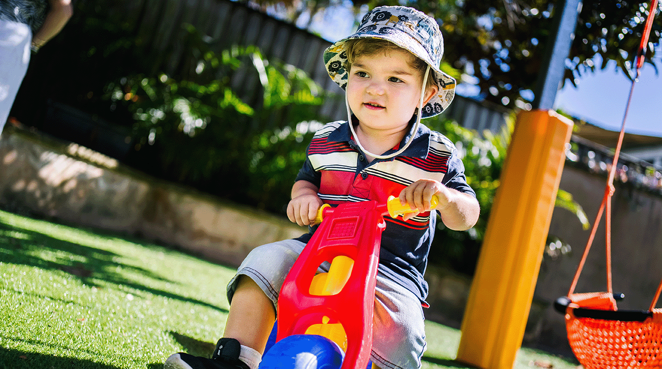 Boy outdoors on tricycle