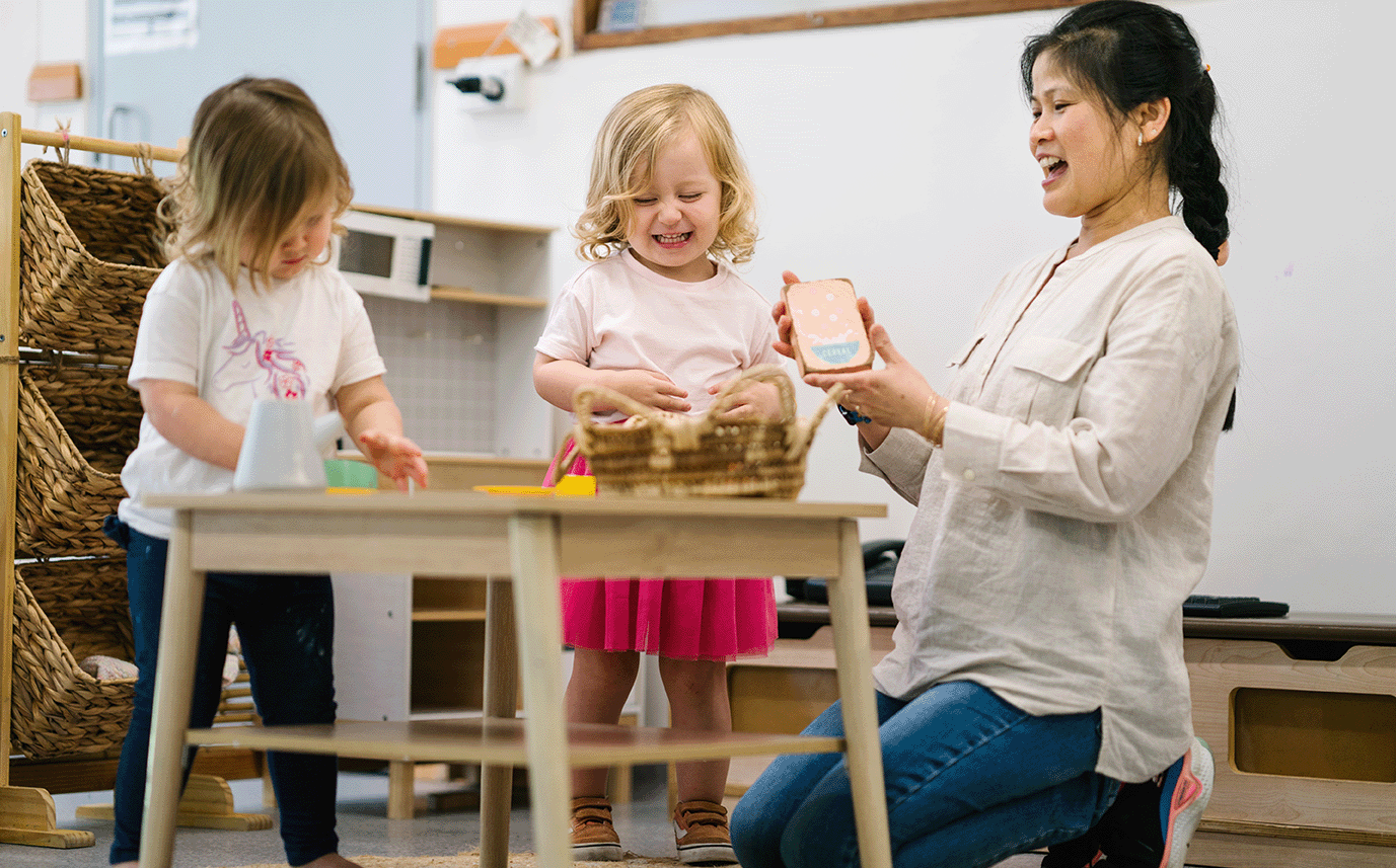 Educator and two children playing indoors