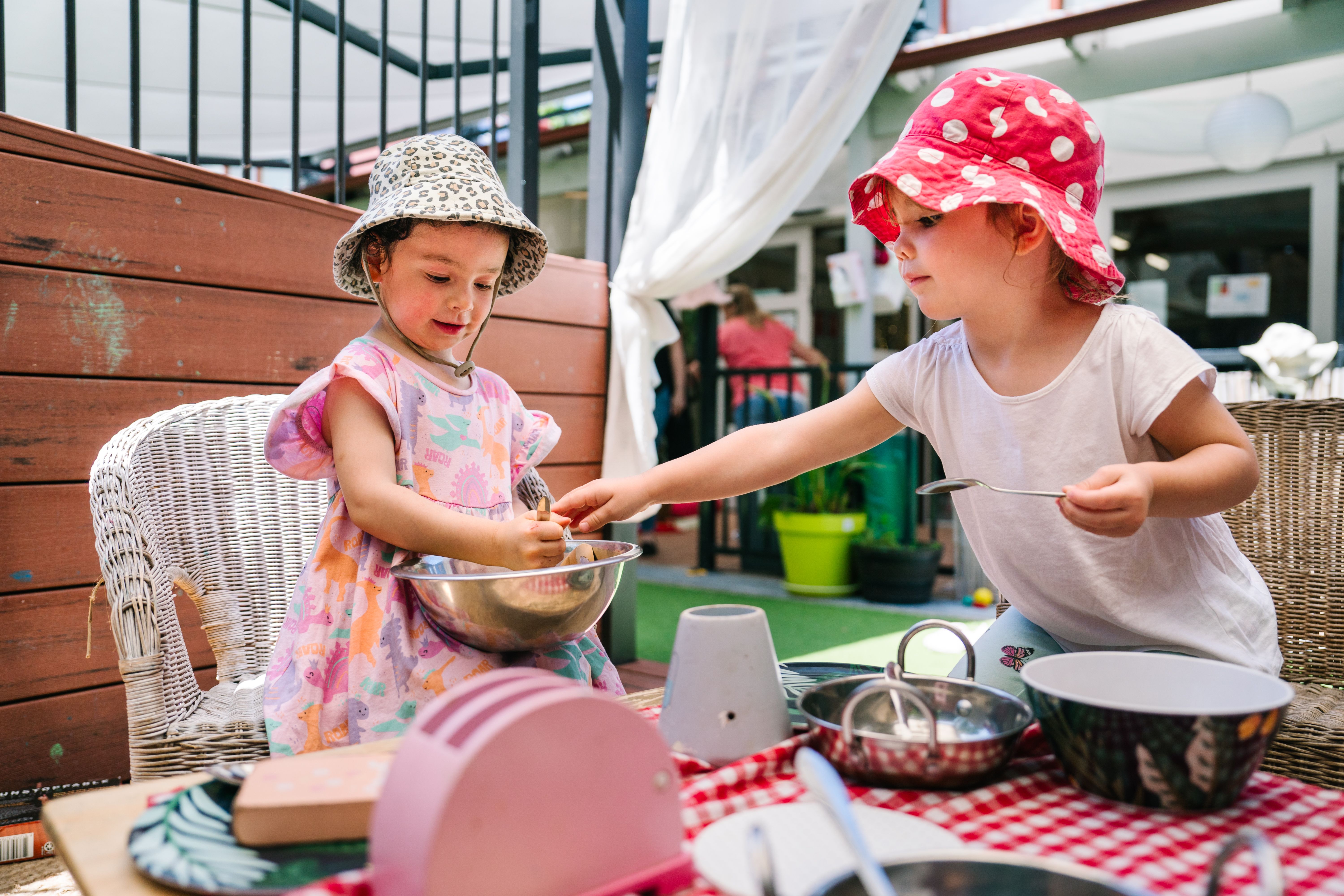 Two girls playing with toy kitchen