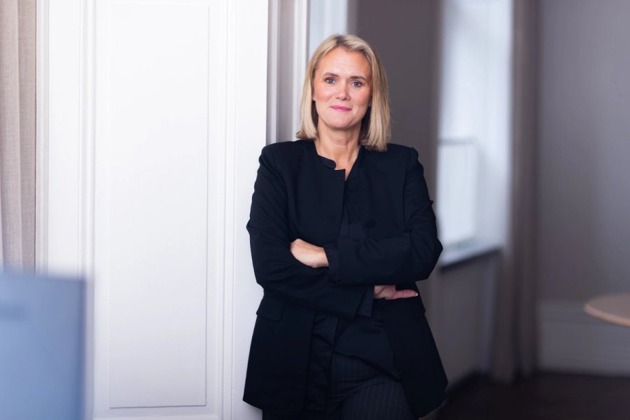 Två kollegor arbetar tillsammans vid en bärbar dator i ett ljust kontor
