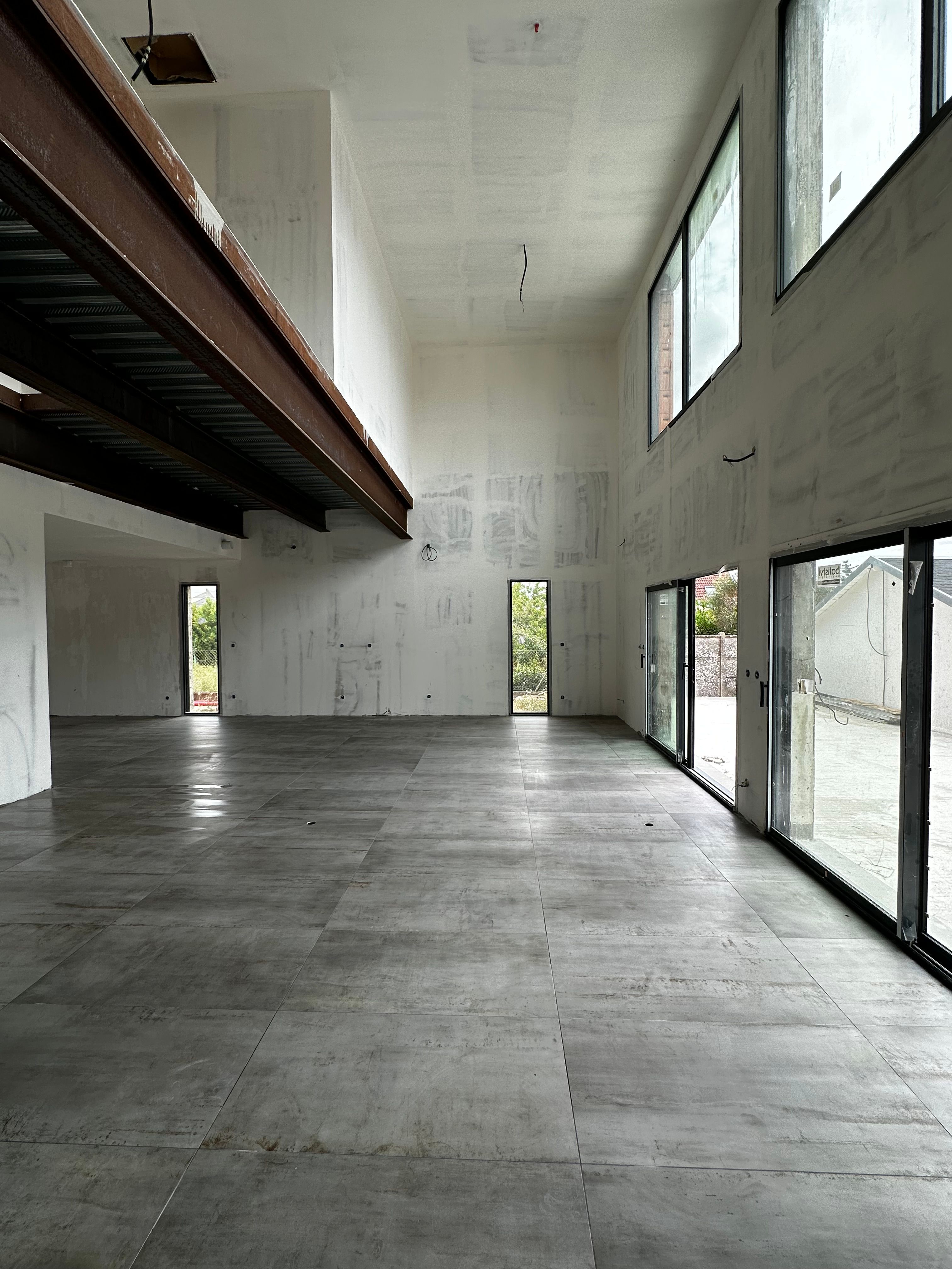 Intérieur moderne avec escalier en béton brut et sol en carrelage grand format