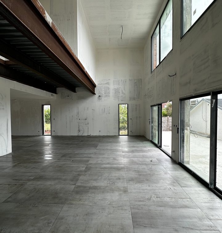 Intérieur moderne avec escalier en béton brut et sol en carrelage grand format