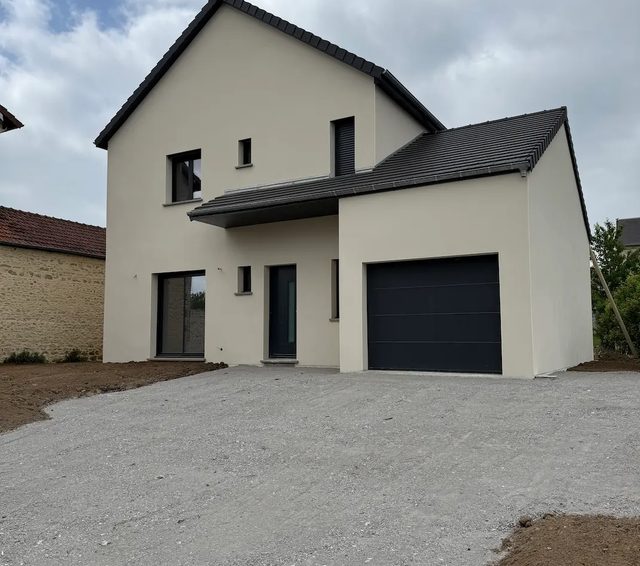 Maison neuve terminée avec façade blanche, toiture grise et allée pavée