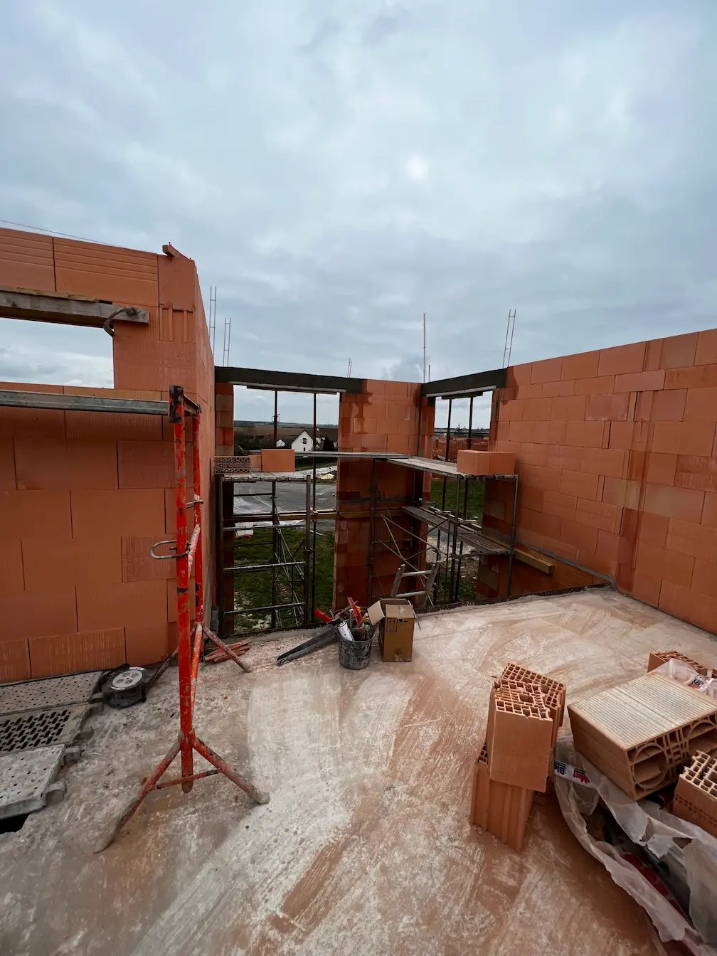 Murs en briques d’une maison en construction avec échafaudage intérieur