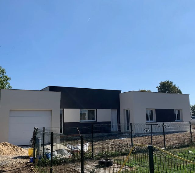 Maison contemporaine terminée avec façade blanche, toit plat et aménagement extérieur