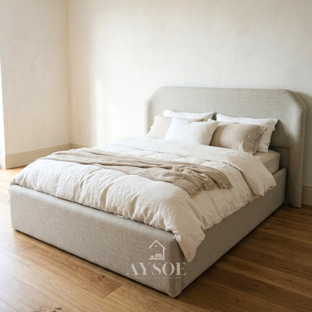 A clean, minimalist upholstered bed in light woven linen-style fabric, with a soft rounded headboard and a fully wrapped, low-profile frame. Calm, neutral, and easy to style.