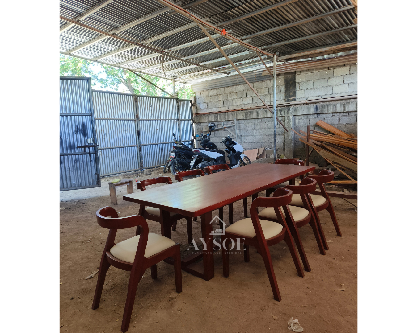 A large dining set with a long solid wood table in a rich red-mahogany finish and eight curved hoop-back chairs with cream leatherette seats. Sturdy, wipe-clean, made to order.