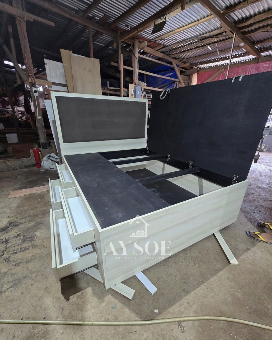 A light oak storage bed with a lift-up platform, four side drawers, and a padded grey headboard. Huge hidden storage for bedding, clothes, and extras.