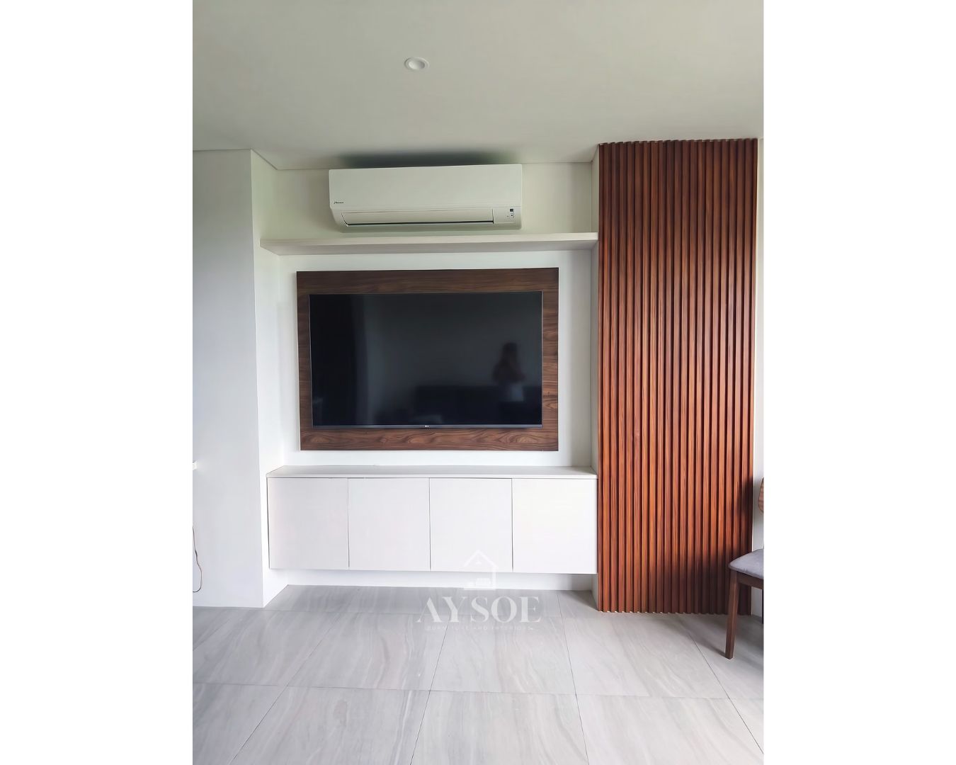 Custom floating TV unit with sleek white cabinetry, wood-finish TV panel, and vertical slat accent wall.