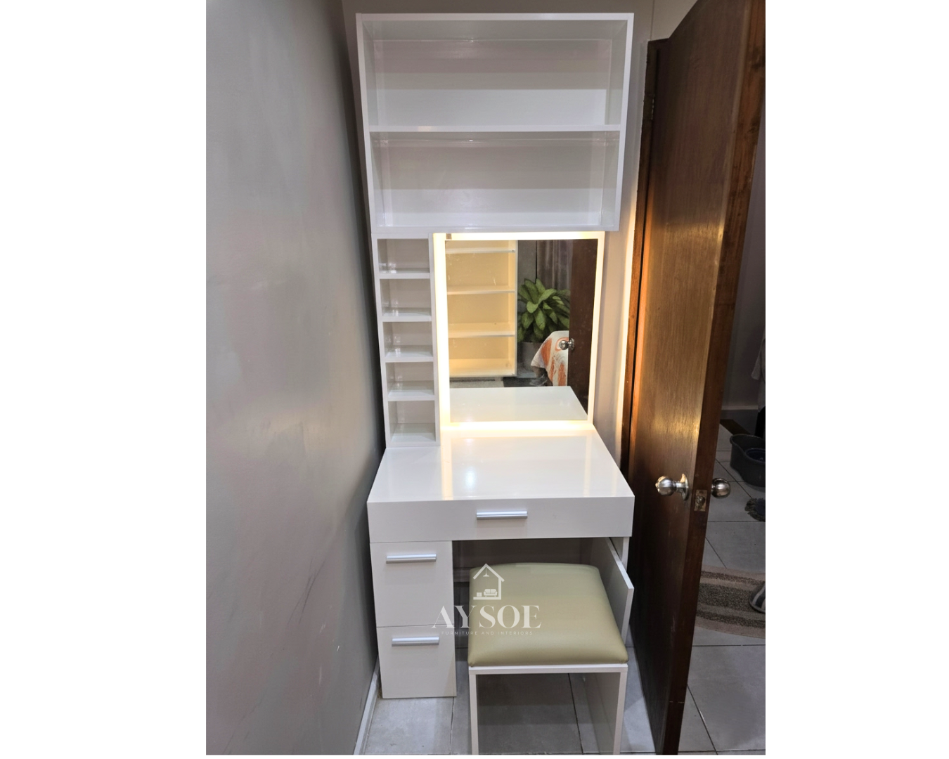 A compact white vanity dresser with an LED-lit mirror, three drawers, open shelves, and a cushioned stool. Perfect for makeup and grooming in small bedrooms.