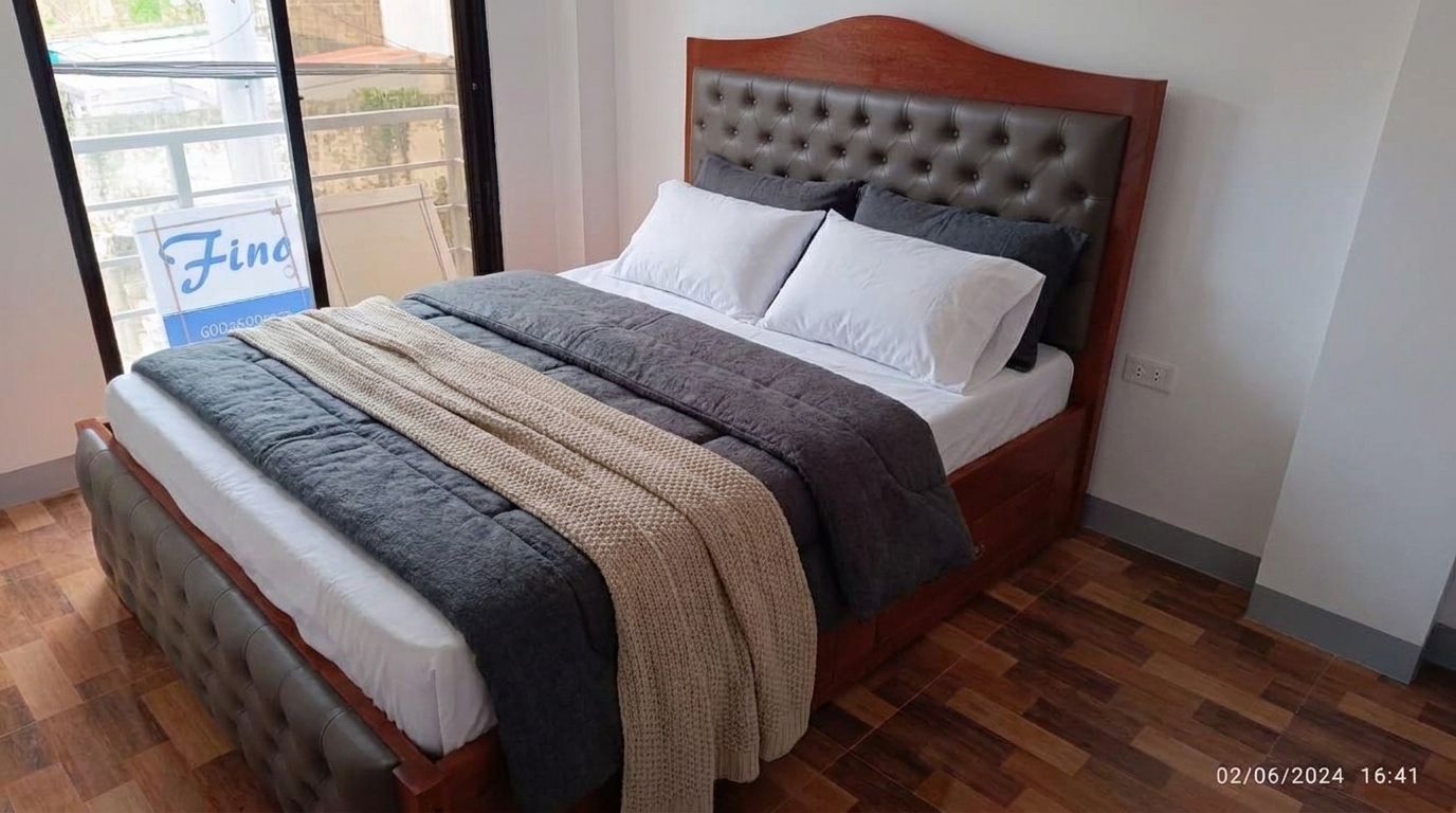 A solid wood bed in a rich glossy cherry finish, with an arched headboard, taupe button-tufted leatherette panels on the headboard and footboard, a slatted base, and built-in side drawers.