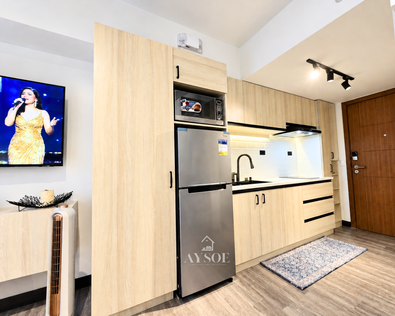 A modern straight kitchen cabinet set in a light oak wood-grain finish, with upper and lower cabinets, three drawers, and a tall pantry tower. Clean, bright, and space-saving.