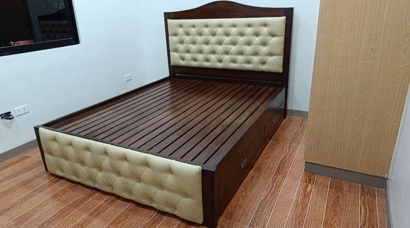 A solid wood bed in a deep walnut finish, with an arched headboard, cream button-tufted leatherette panels on the headboard and footboard, a slatted base, and built-in side drawers. Classic, warm, and practical.