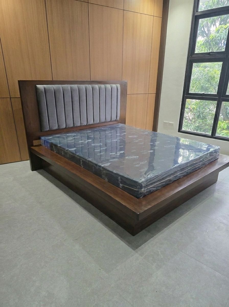 A modern dark walnut platform bed with a wide wood ledge, a recessed base for a floating look, and a tall wood headboard with a soft gray channel-tufted panel. Clean, solid, and built to last.