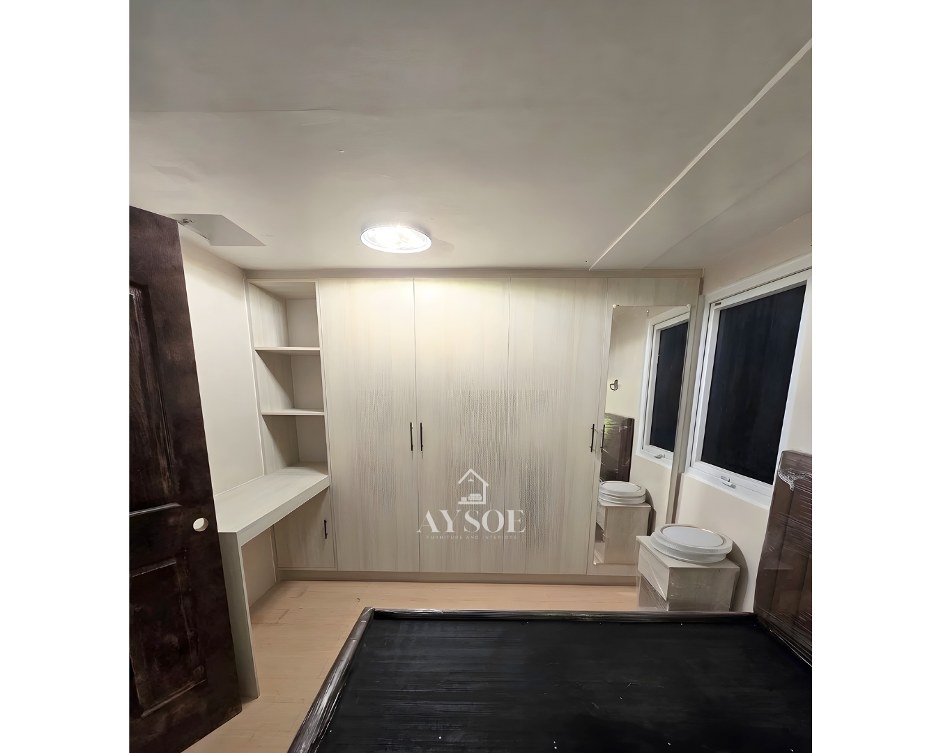 A custom light oak wardrobe with four full-height doors, a full-length mirror, built-in open shelves, and a desk counter. Complete bedroom storage in one clean design.