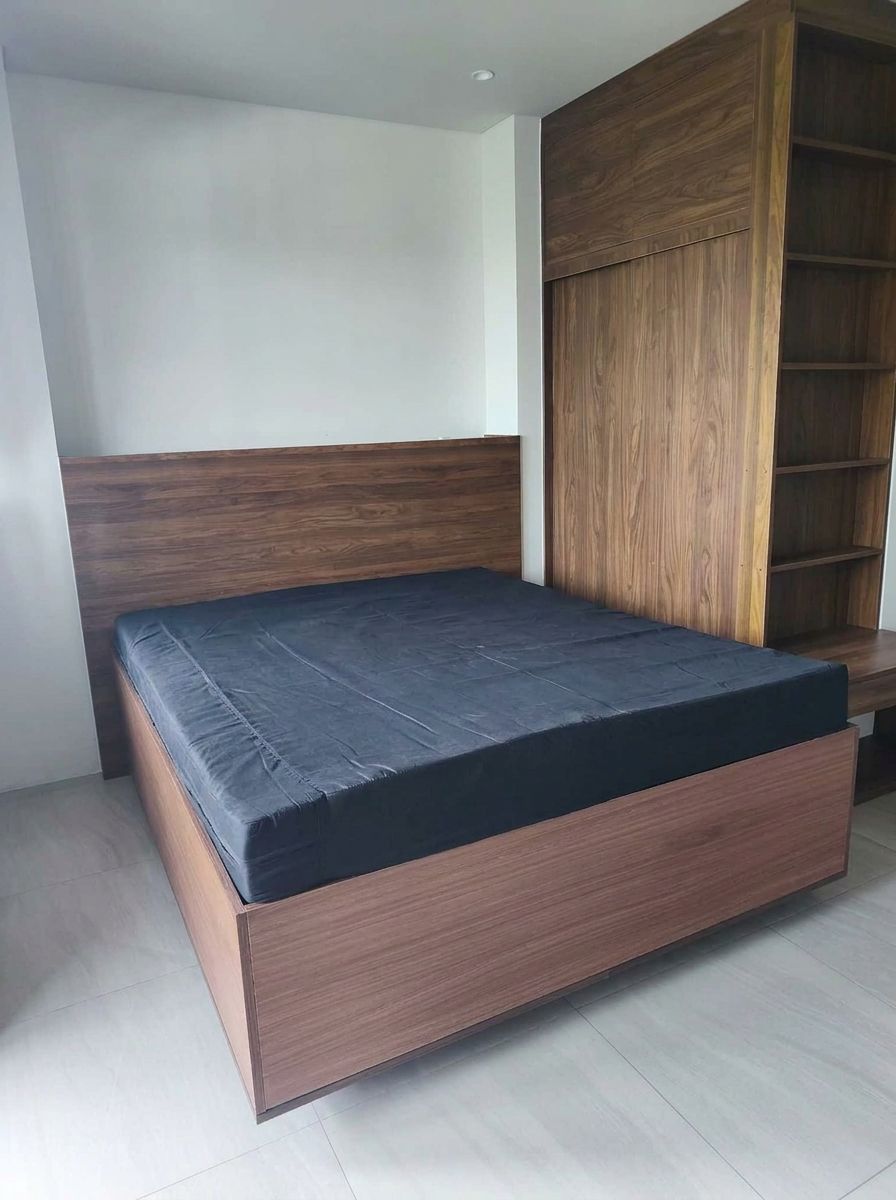 A modern walnut wood-grain platform bed that looks like it’s floating, with warm LED lighting underneath and a full-width panel headboard. Clean lines, rich grain, and a calm, hotel-style glow.