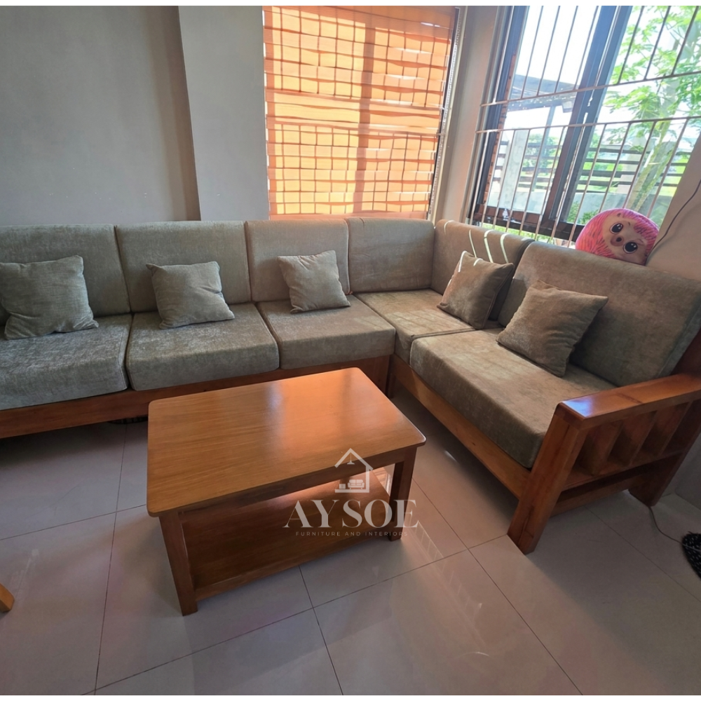 It is topped with thick, structured cushions upholstered in a sage green or muted olive fabric, complete with several small matching square throw pillows.