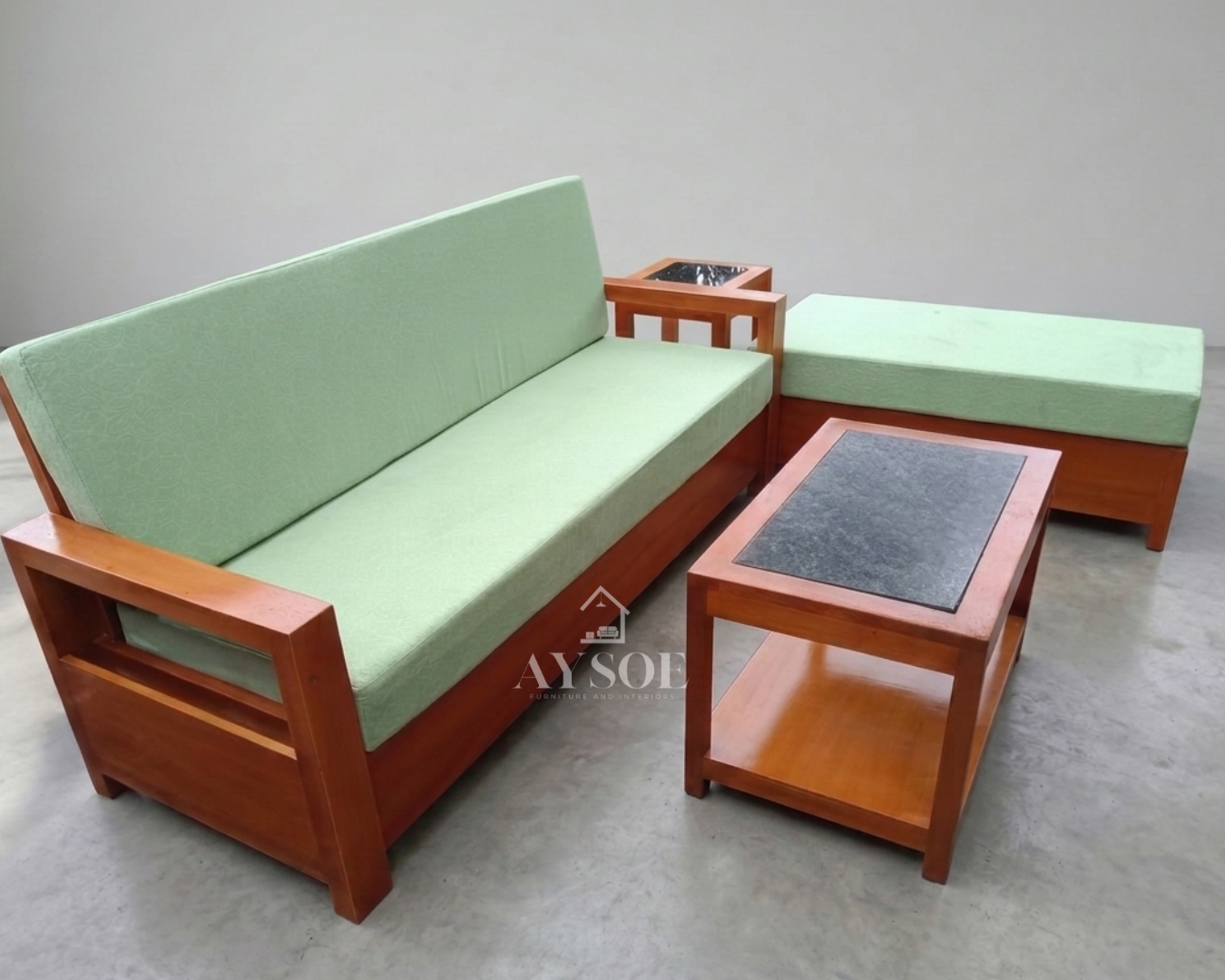 A 4-piece living set with a honey-cherry solid wood frame and soft mint-green cushions: a three-seater sofa, a chaise bench, a stone-inset coffee table, and a matching side table. Fresh, sturdy, made to order.