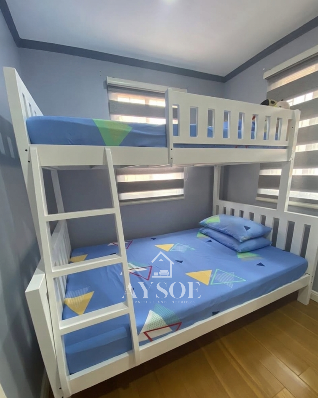 A white solid wood bunk bed with a single upper bunk, a wider lower bed, slatted guard rails, and a side ladder. Sturdy, clean-looking, and space-saving for shared rooms.