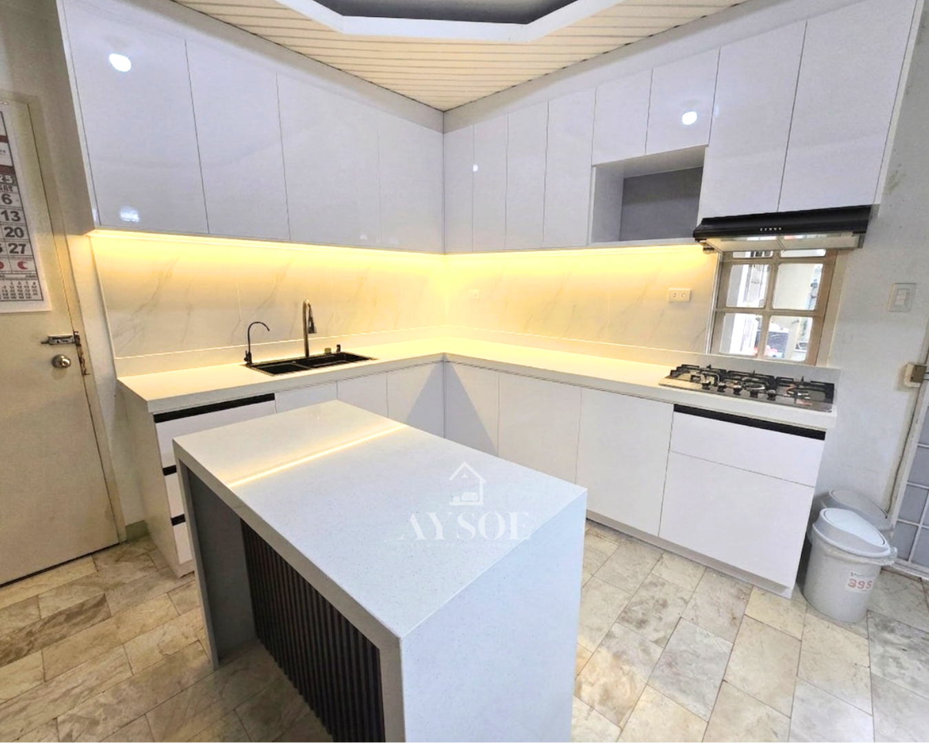 A high-gloss white L-shaped kitchen with a marble-look backsplash, LED lighting, and a waterfall island.