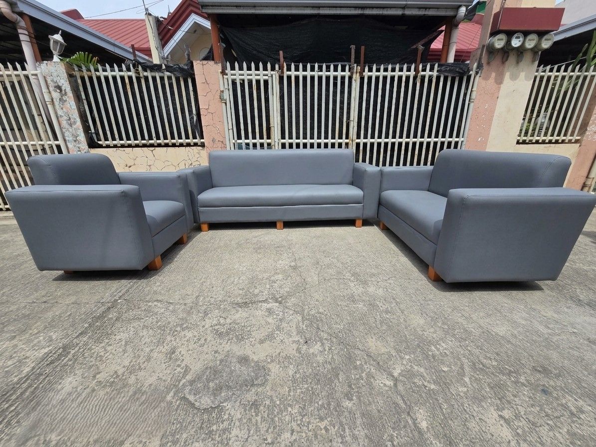 The Seating Arrangement: A long 3-seater sofa anchors the back wall, flanked symmetrically by two large, deep matching single-seater armchairs facing inward.