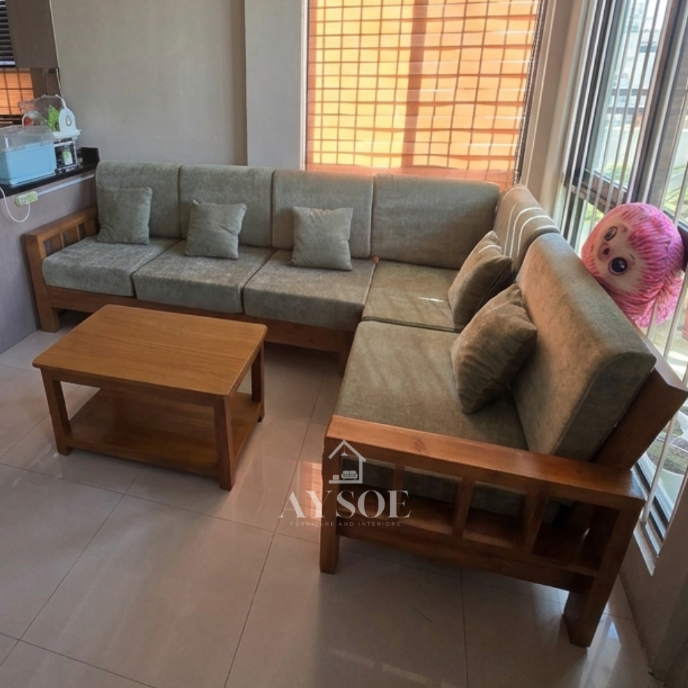 It is topped with thick, structured cushions upholstered in a sage green or muted olive fabric, complete with several small matching square throw pillows.