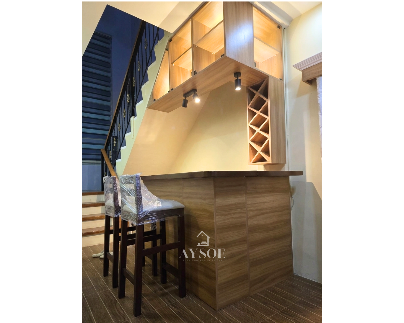 A custom home bar set with a wood-grain bar counter, lighted glass display cabinets, spotlights, and a diamond wine rack. Turns an unused corner into a stylish home bar.