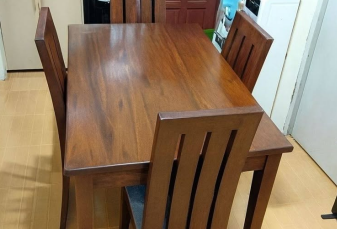 Chairs: Four matching slat-back chairs featuring slightly curved vertical wooden slats along the backrests.