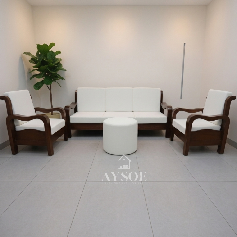 A cylindrical, fully upholstered white round ottoman sits directly in the center, functioning as a modern coffee table or footrest.