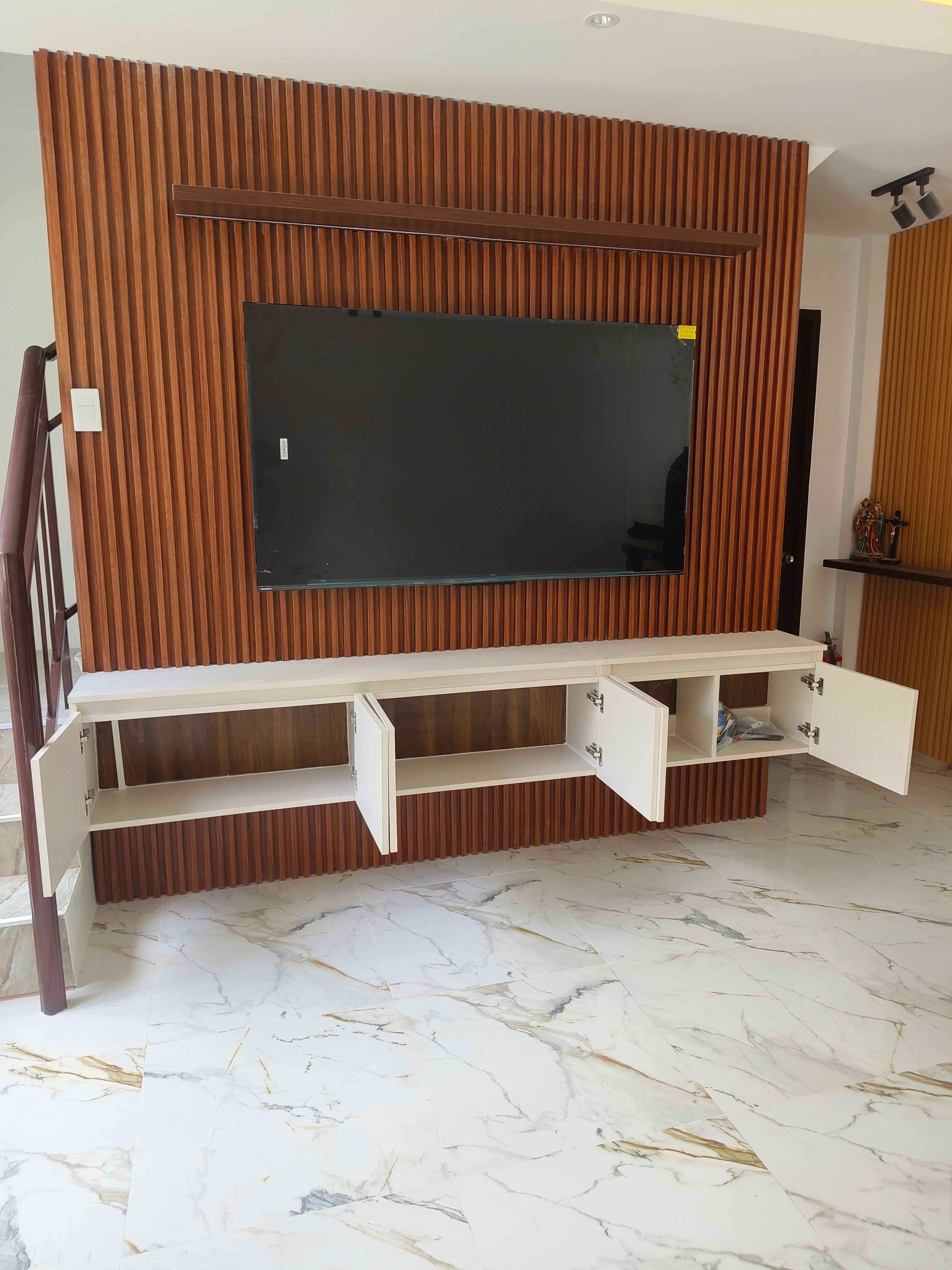 Floating white TV console with a warm slatted wood feature wall and matching accent panel.