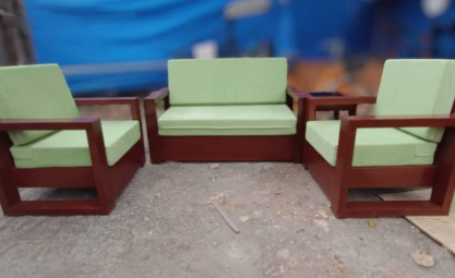 The structured seat and back cushions are upholstered in a contrasting light mint green or pastel green fabric.